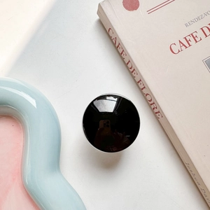 Close-up of minimalist black round glass phone socket with reflective mirror surface finish