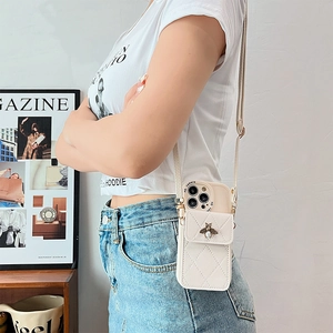Cream quilted iPhone crossbody case with pearl bee emblem and adjustable long strap