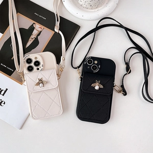 Detailed view of quilted leather phone case with pearl bee emblem and crossbody strap