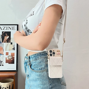 Detail view of quilted cream iPhone wallet case with an adjustable crossbody strap on a model