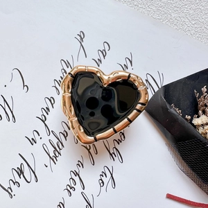 Metallic heart phone socket holder in gold and black enamel with textured frame