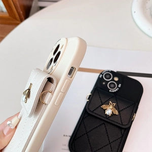 Detail of quilted leather card holder case with pearl bee emblem for iPhone