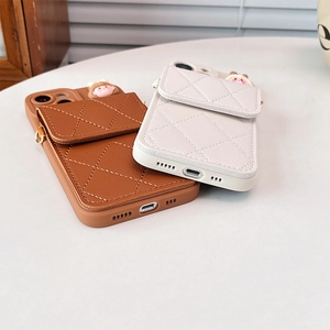 Close-up of diamond quilted leather phone cases with card wallet and cartoon girl charms