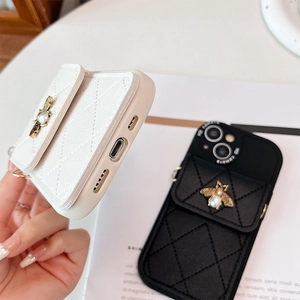 Detail of quilted leather phone case with card holder and gold pearl bee accent