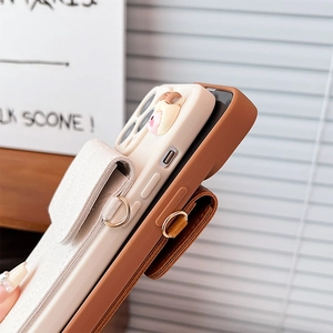 Close-up of quilted leather card holder on phone case with gold metal D-ring attachment