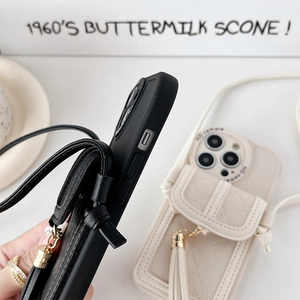 Detail of quilted leather phone case with card holder, tassel, and crossbody strap