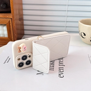Close-up of white quilted wallet phone case with cute cartoon animal decor and soft lighting