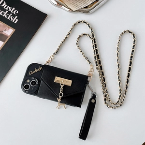 Détail d'une coque en cuir noir avec pendentif cerf doré et chaîne bandoulière élégante