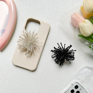Detail of off-white lychee leather phone case with 3D sea urchin-shaped charms