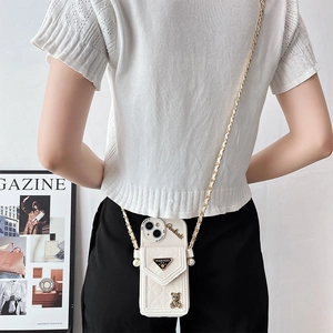 Detailed back view of a white quilted crossbody phone case with chain and bear charm