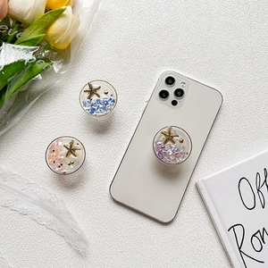 Starfish glitter phone grip with seashells and sequins for a stylish desktop support