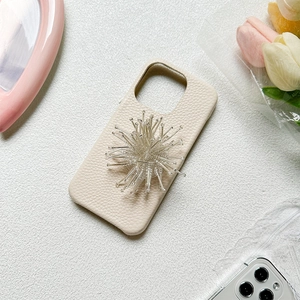 Off-white lychee leather iPhone case with radial crystal bead grip on a floral background
