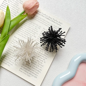 Close-up of radial bead phone socket accessory with black and transparent bead details