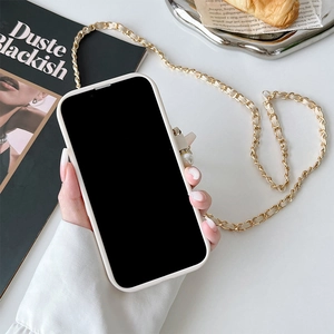 Cream crossbody iPhone case with pearl clasp and golden chain strap in a lifestyle setting