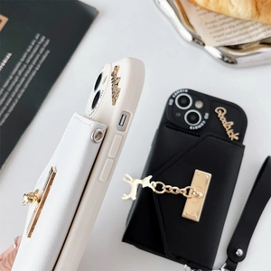 Gros plan d'une coque iPhone avec porte-cartes en cuir, pendentif cerf et chaîne chic