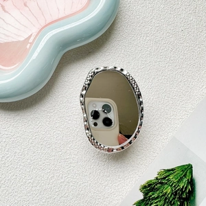 Detailed view of silver hammered metal phone grip with built-in oval vanity mirror