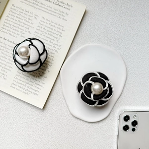 Close-up of pearl camellia flower phone sockets in black and white fabric styles