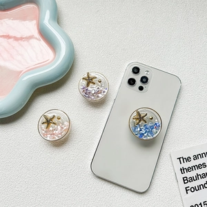 Detail of star-shaped starfish phone grip with colorful sequins and glitters inside
