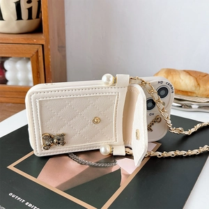 Close-up of quilted leather phone case with bear ornament, pearl charm, and gold chain