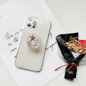 Starfish phone socket grip with glitter and pearls on a white smartphone back