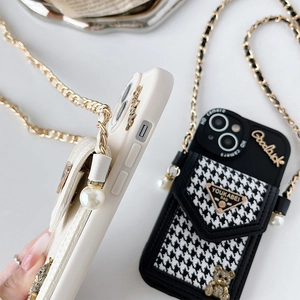 Detailed view of iPhone case featuring houndstooth card pocket and gold bear emblem