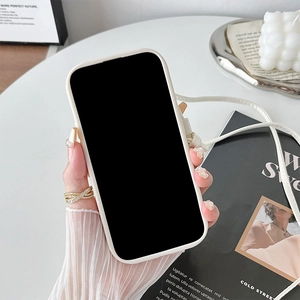 Cream silicone phone case with crossbody strap held over minimalist decor