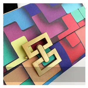 Macro detail of Saffiano leather texture with colorful geometric patterns and gold metal clasp