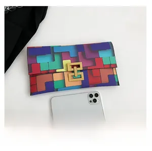 Detail view of colorful geometric contrast clutch bag with metal clasp and phone comparison