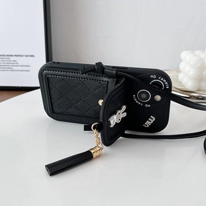 Detail of quilted leather phone case with bunny charm, tassel, and crossbody strap