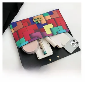 Flat lay of a stylish geometric patchwork envelope clutch showing inner capacity for daily essentials
