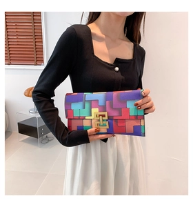Detail of color-block envelope clutch featuring geometric patterns and gold metal clasp