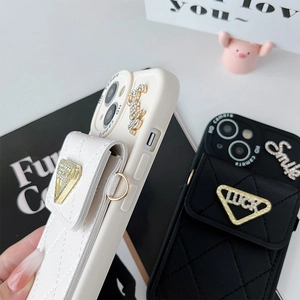 Détail de coque en cuir matelassé avec porte-carte LUCK et breloque Smile en diamants