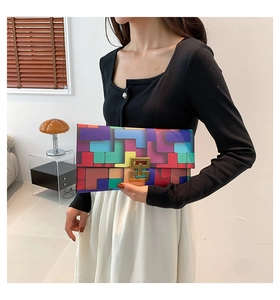 Detail of color-block envelope clutch with multi-color panels and gold metal buckle