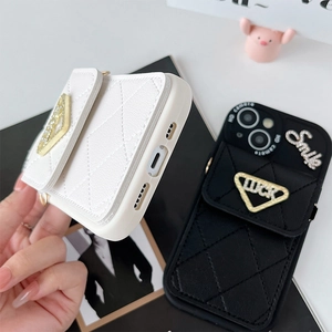 Détail de la coque iPhone en cuir matelassé avec breloques Luck et Smile et triangle métal
