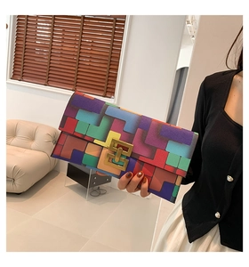 Detail of colorful geometric patchwork clutch bag with golden rectangular metal clasp