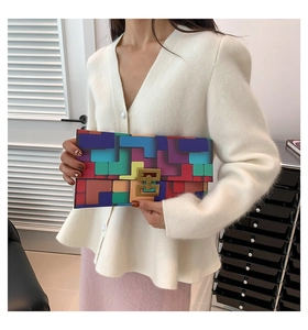 Detail of color-block geometric pattern clutch bag with elegant golden metal lock