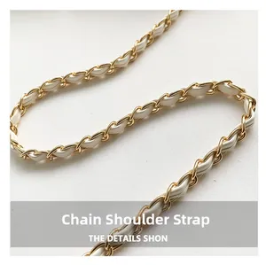 Détail d'une bandoulière en chaîne dorée entrelacée de cuir blanc de luxe