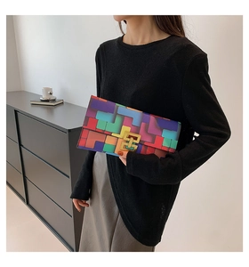 Detail of color-block geometric handbag featuring a gold interlocking metallic clasp lock