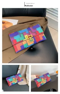 Close-up of multicolor geometric pattern and gold buckle on a stylish envelope clutch