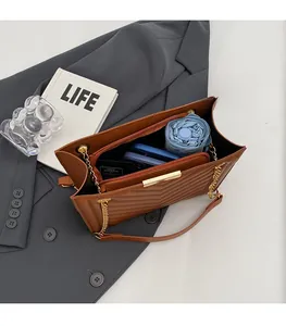 Interior view of brown quilted tote bag showing large capacity for phone and umbrella