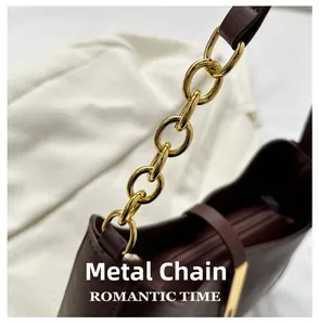 Detail of the golden metal chain connection on this dark brown leather shoulder bag