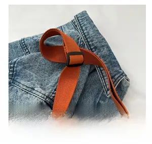 Detail showing the adjustable orange woven shoulder strap with black buckle on corduroy tote bag
