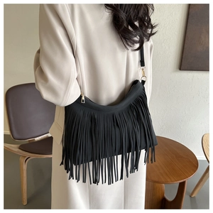 Detail of a black tassel shoulder bag featuring fringe design and gold metal zipper