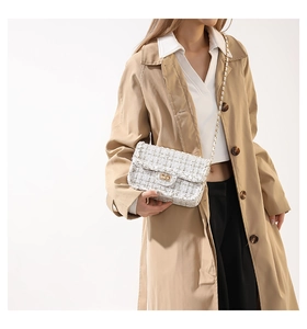 Borsa a tracolla in tweed bianco sporco abbinata a un elegante trench coat classico