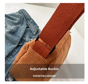 Detail of adjustable buckle and wide woven strap on the brown corduroy tote bag
