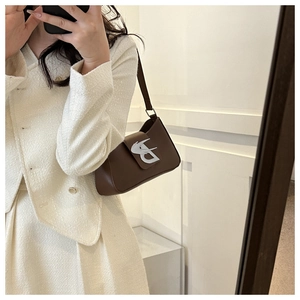 Borsa baguette in pelle marrone con fibbia a B argentata mostrata in un selfie allo specchio