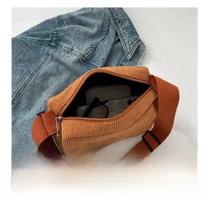 Brown corduroy crossbody bag interior showing storage space for phone and glasses