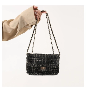 Détails de la texture tweed et fermoir doré sur le sac à carreaux noir et doré