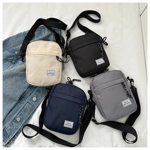 Flat lay of colorful nylon shoulder bags with HELLO WEEKEND patches and black straps