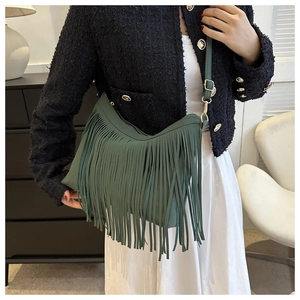Detail of forest green hobo bucket bag featuring long fringe tassels and adjustable strap